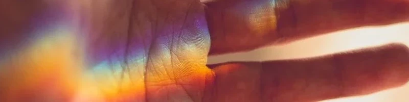 In einer Handfläche ist ein Regenbogen zu sehen
